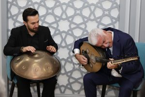 Two musicians playing oud and handpan in a cozy indoor setting, conveying cultural richness and musical harmony. — 10 Commonl