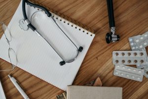 Flat lay of medical tools and supplies on a wooden desk surface. — 3 Things to Pay Attention to in Locum Contracts