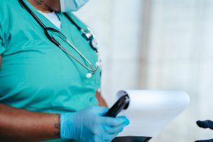 Side view of crop anonymous tattooed ethnic female medic in uniform with stethoscope and papers on clipboard — 6 Ways Familie