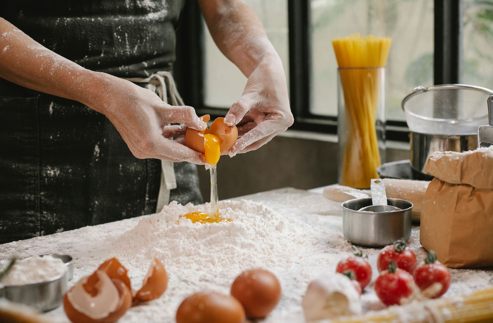 Crop anonymous person adding egg in flour while cooking pastry for recipe with cherry tomatoes and spaghetti — 8 Most Fatteni