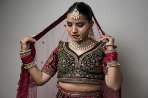 Stunning portrait of an Indian bride in traditional attire, showcasing intricate jewelry and detailed embroidery. — At Home P