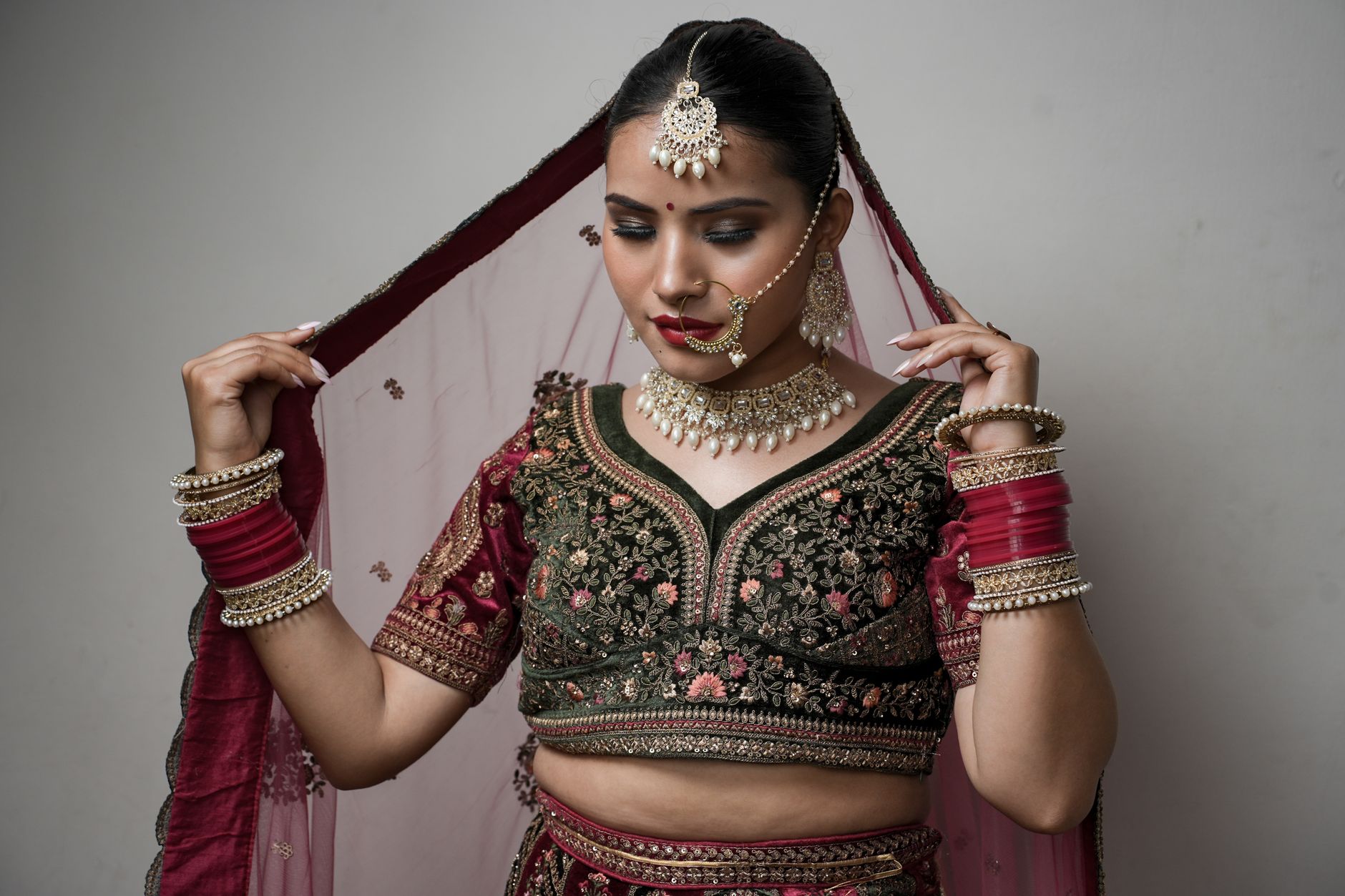 Stunning portrait of an Indian bride in traditional attire, showcasing intricate jewelry and detailed embroidery. — At Home P