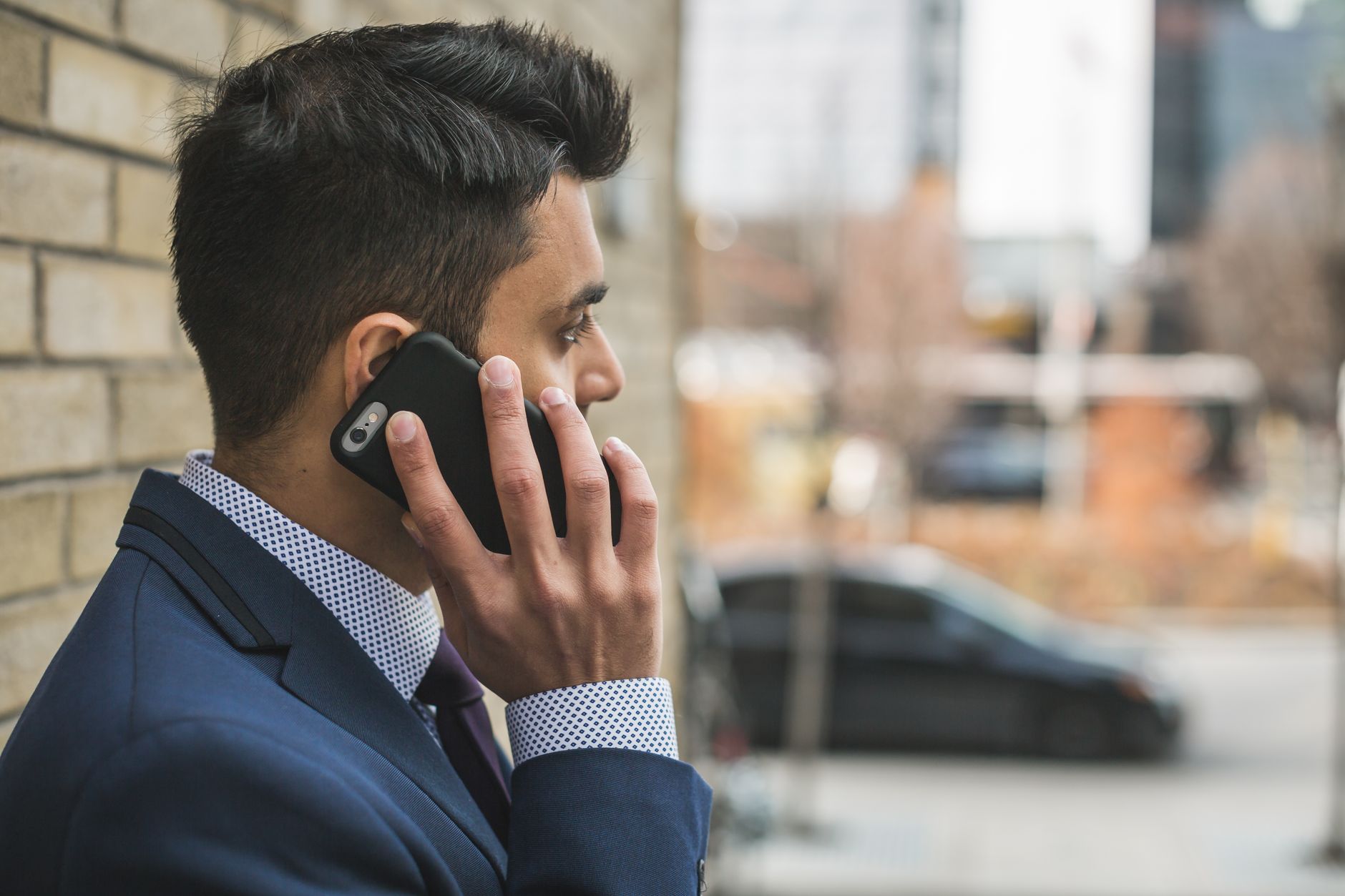 Professional man in suit making a phone call outside in city setting. — Crafting Confidence: The Role of California Dental La