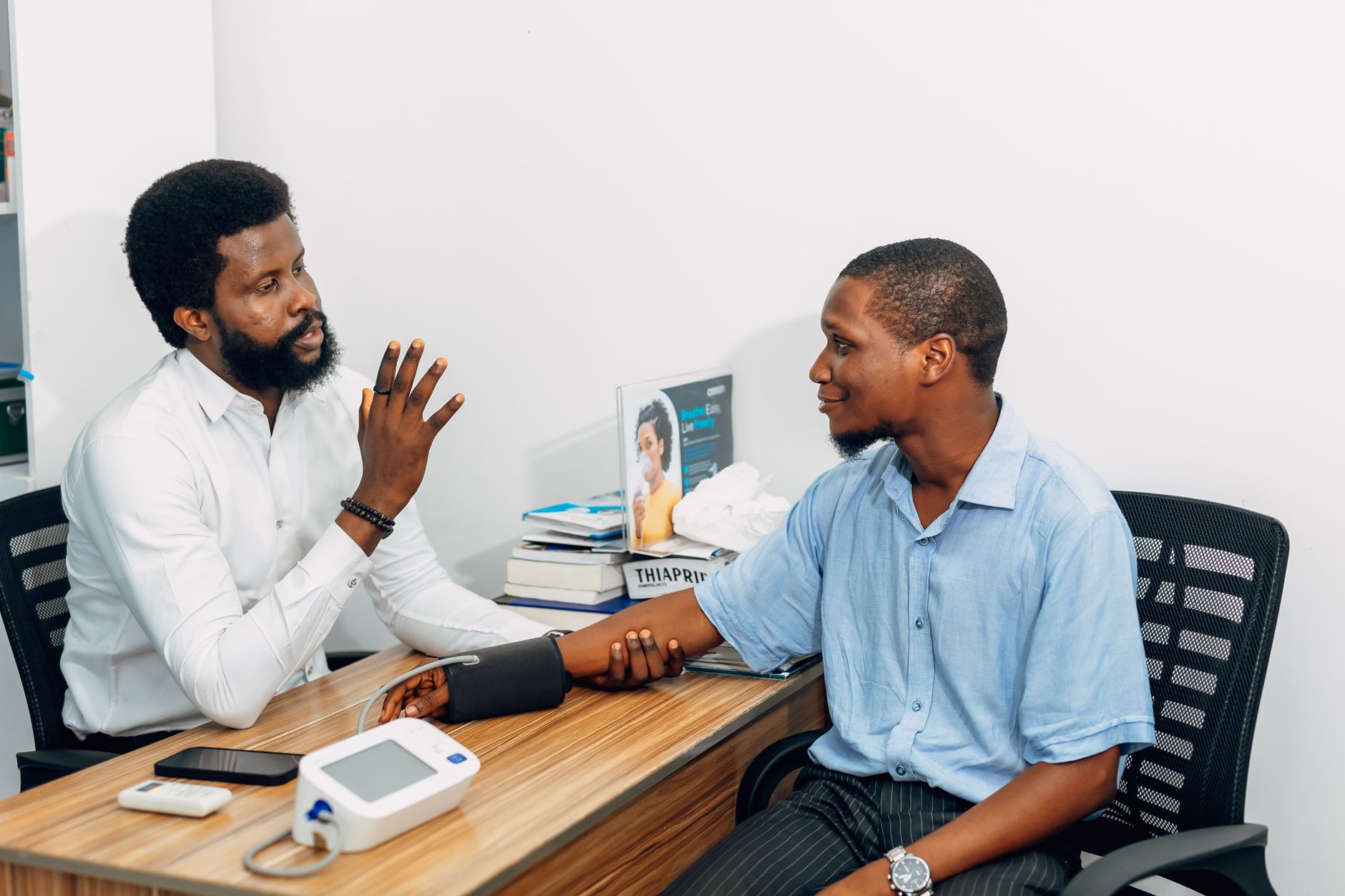 A medical professional consults with a patient during a blood pressure checkup in Lagos, Nigeria. — Delightful Delta 10: Unve
