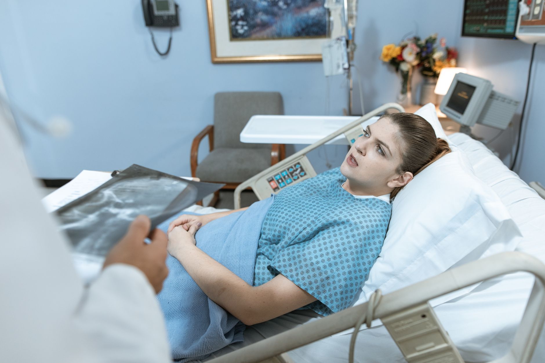 Caucasian woman in hospital bed receiving care from healthcare professional. — Dental Health Is Not Only About Your Mouth