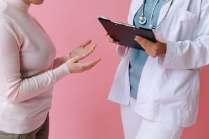 Close-up of a patient consulting a doctor with a clipboard in a medical setting. — Dermatologists' Advice On Dealing With Oil