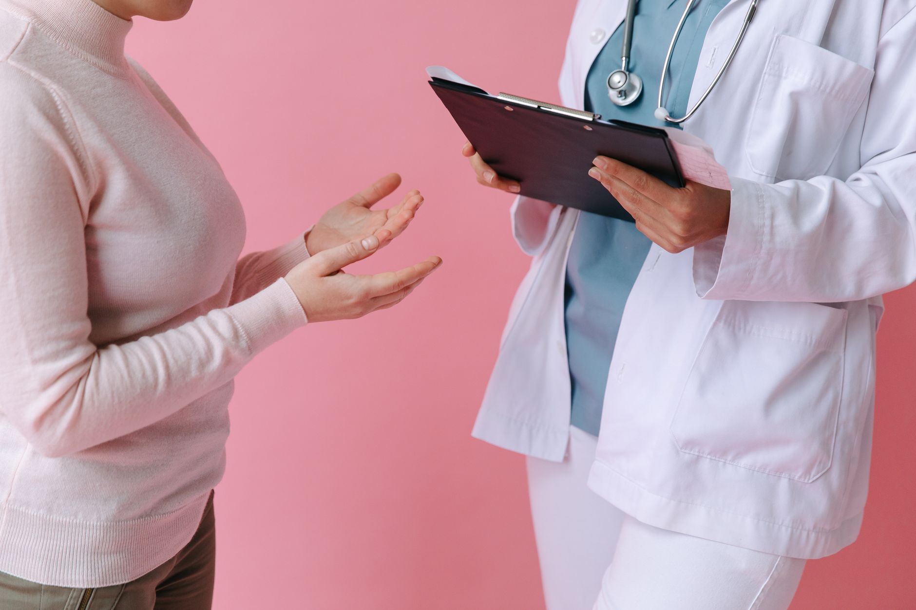 Close-up of a patient consulting a doctor with a clipboard in a medical setting. — Dermatologists' Advice On Dealing With Oil