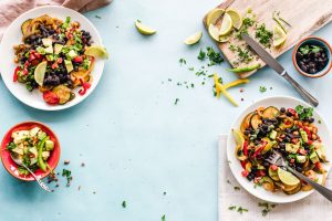 Colorful Mexican salad with avocado, black beans, and lime on a light blue surface. — Elements Brasserie Weekly Deals: Great