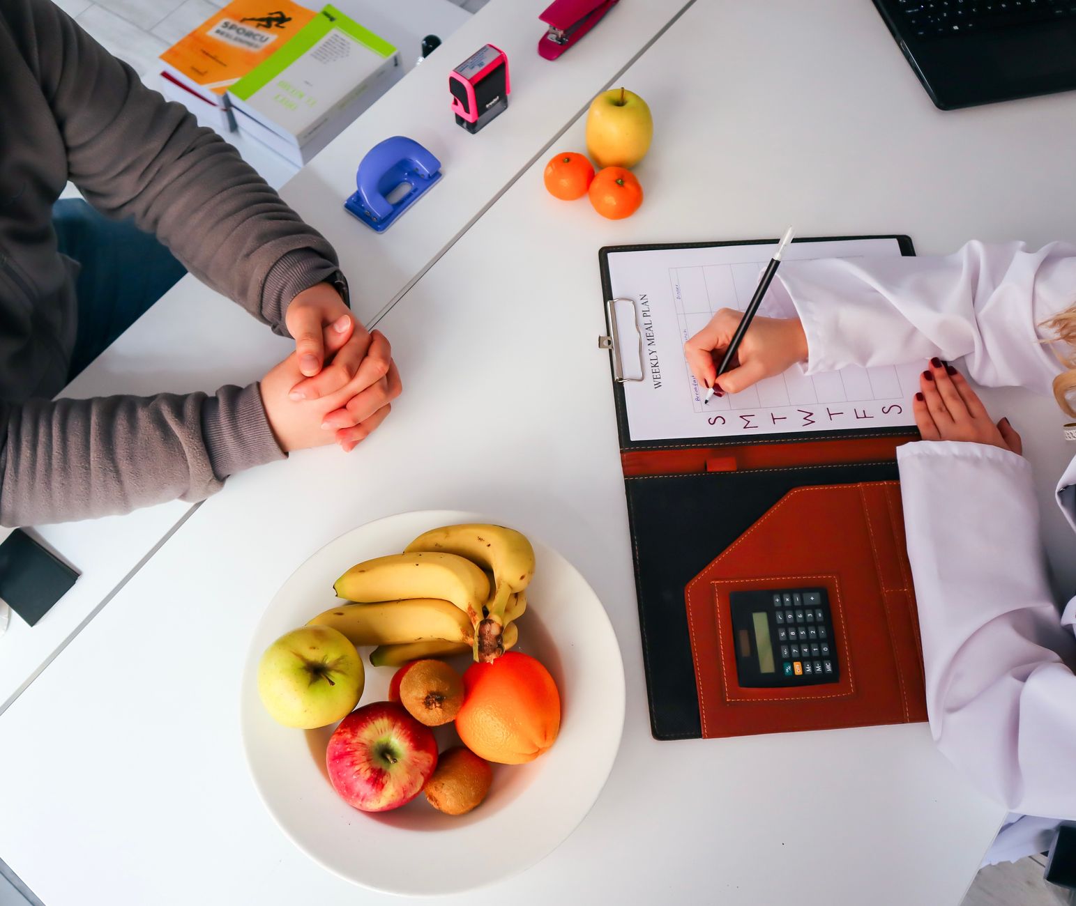 Top view of a dietitian planning a healthy diet with fresh fruits on the table, focusing on health and nutrition. — Hemi Phar