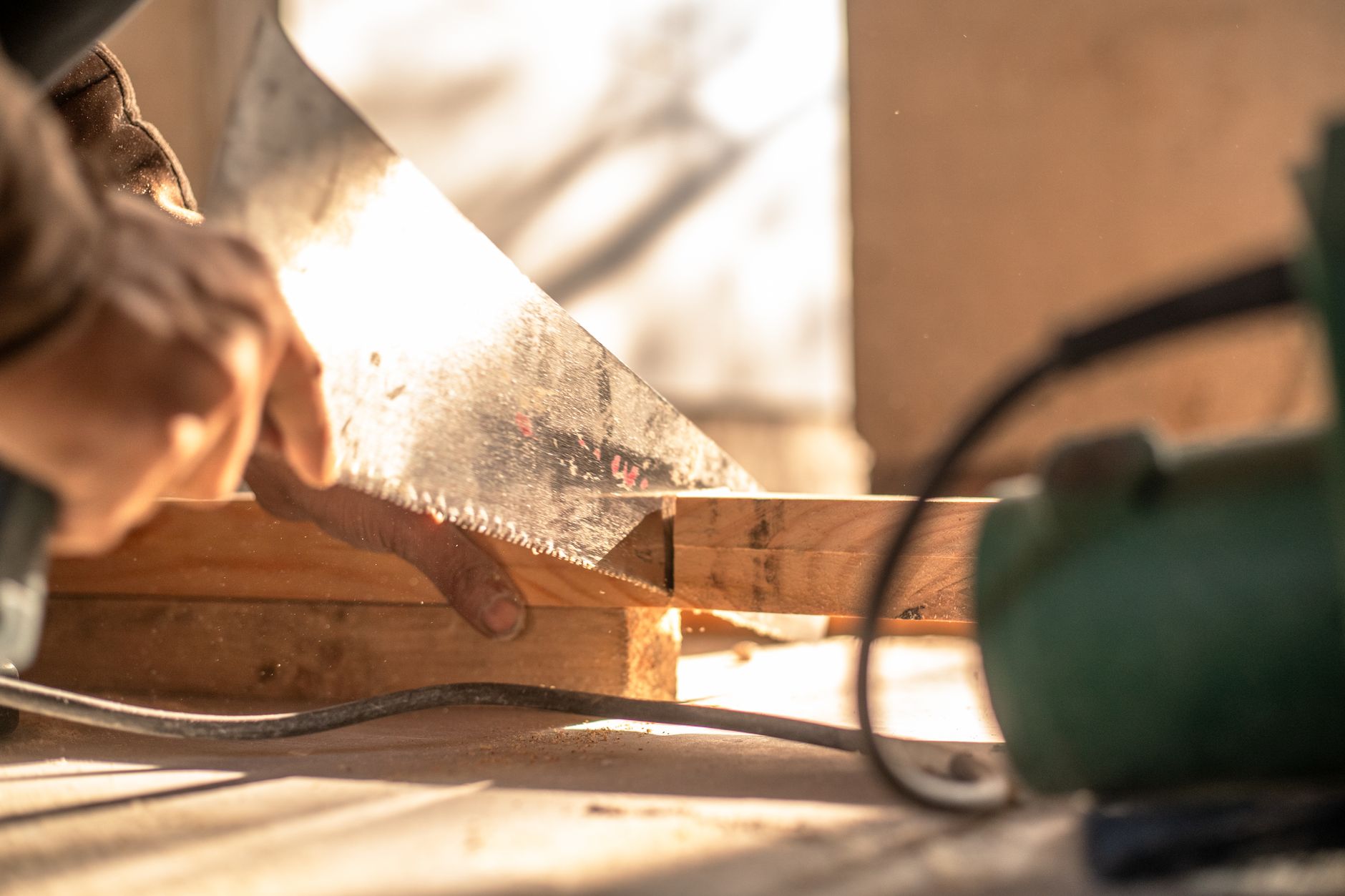 Carpenter cutting wood with a hand saw, showcasing craftsmanship and precision. — High-Quality Acoustic Panelling Offering Fu