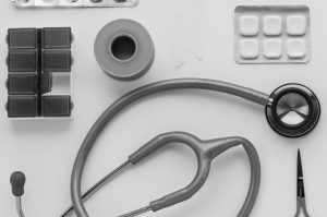 Top view of medical instruments and pills arranged on a white background. — Homeopathic solution for skin allergy