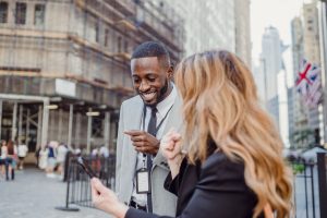 Two business professionals engage in lively conversation on an urban street, sharing insights. — How to clean your washing ma