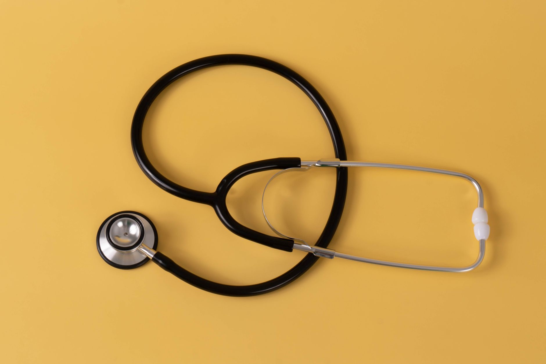 Close-up of a black stethoscope on a vibrant yellow surface, ideal for medical themes. — How to Dilute Essential Oils: An Ult