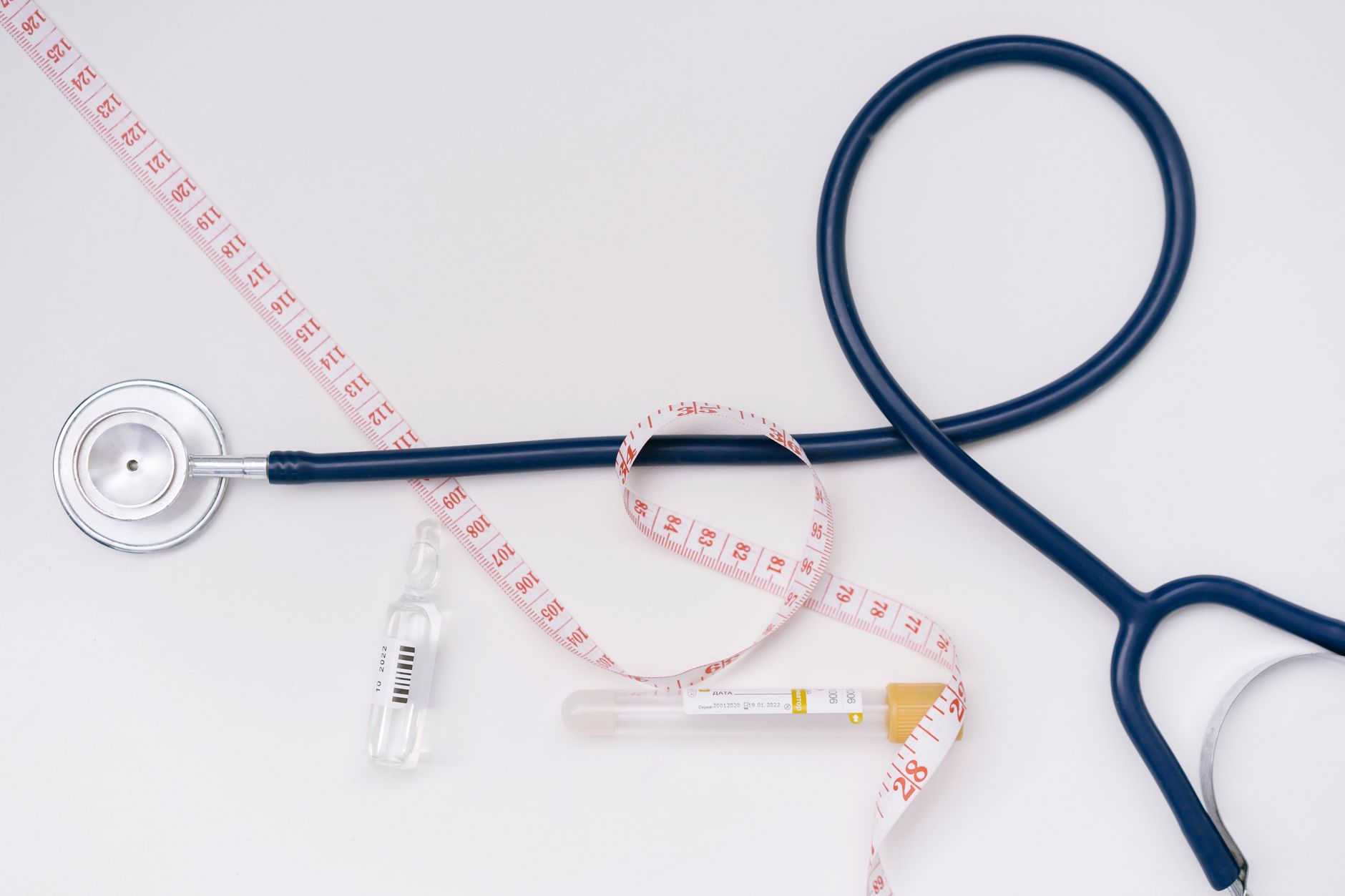 A stethoscope, ampoule, and tape measure on a white background symbolize healthcare essentials. — How to Find the Best Medica
