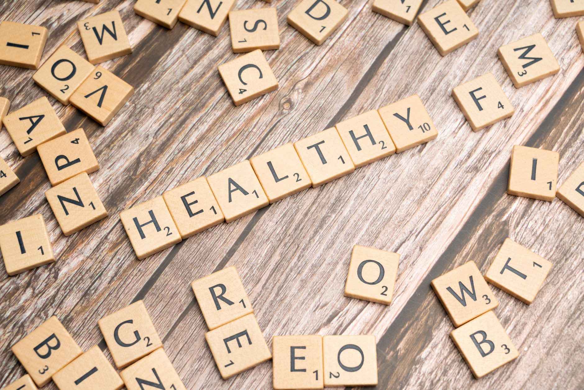 Wooden letter tiles arranged on a wooden surface spelling out 'healthy', symbolizing wellness. — Important Considerations Bef