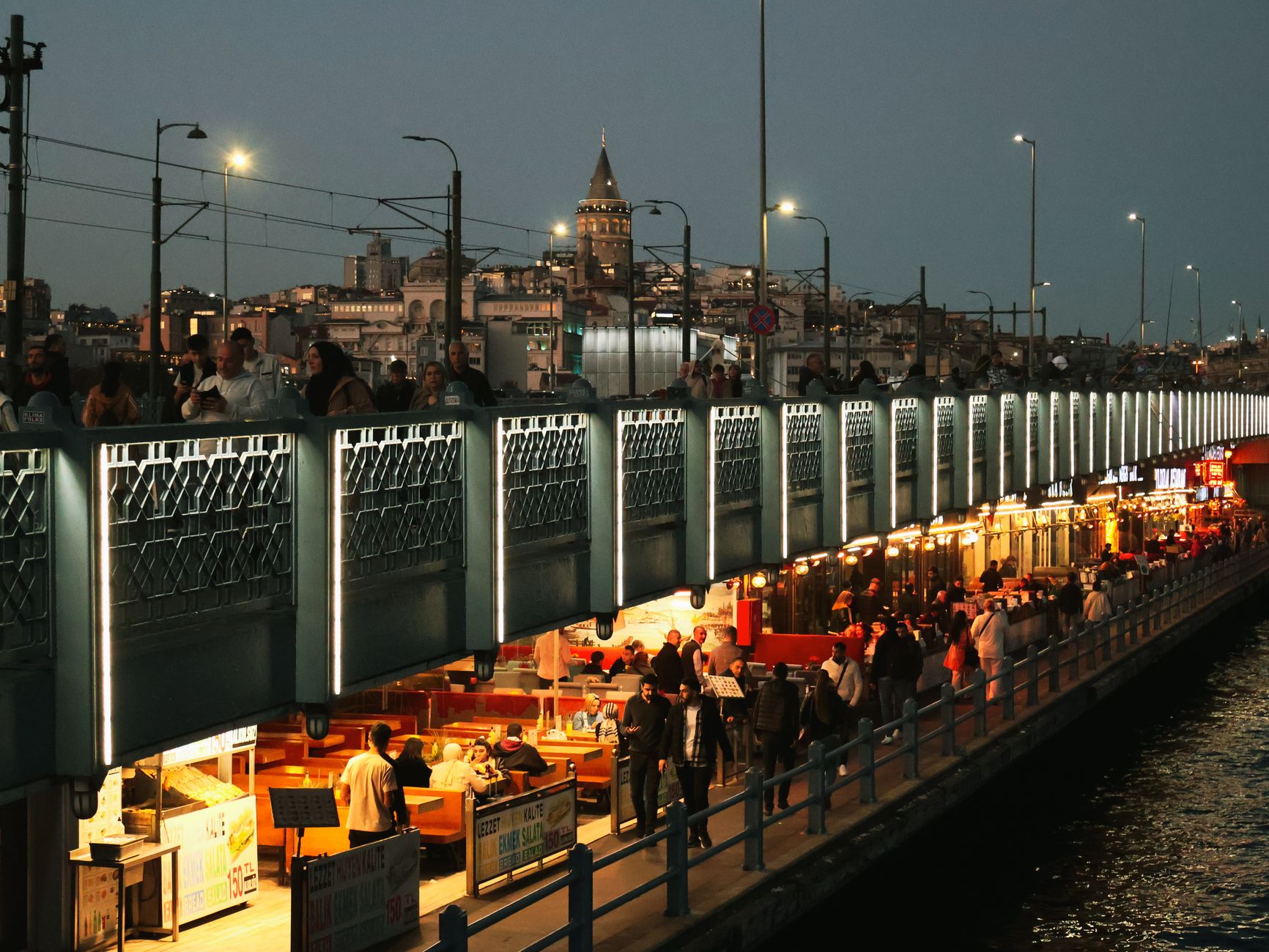 Night view of Galata Bridge bustling with people and distant Galata Tower in Istanbul. — Is Invisalign a Good Option for Teen