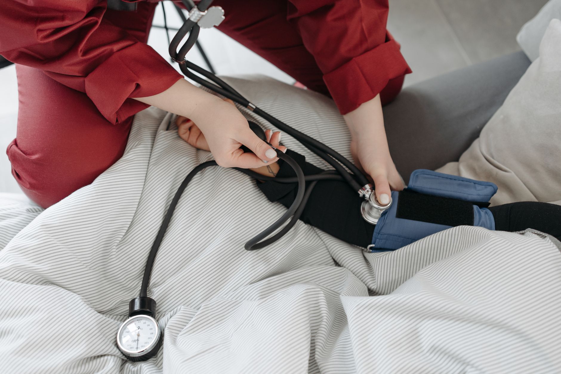 A medical professional checking a patient's blood pressure using a sphygmomanometer in a cozy setting. — Isolate Protein's Si