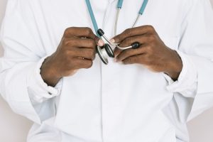 A professional doctor holding a stethoscope, focusing on hands and medical tools. — Know About Things Which Covered Under Med