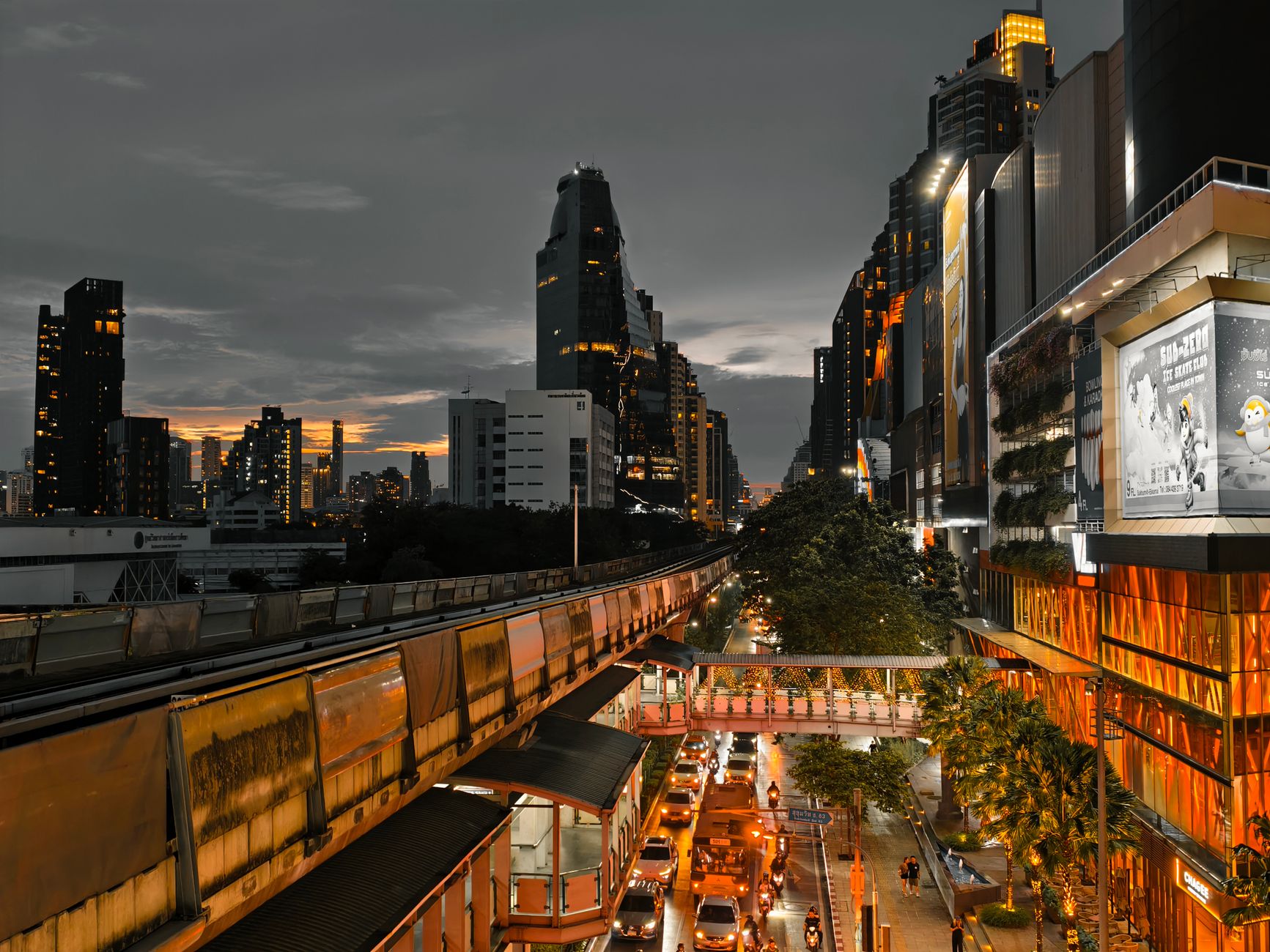 Cityscape at twilight showing busy traffic, skyscrapers, and an elevated train line in an urban setting. — Legal Purchases Av