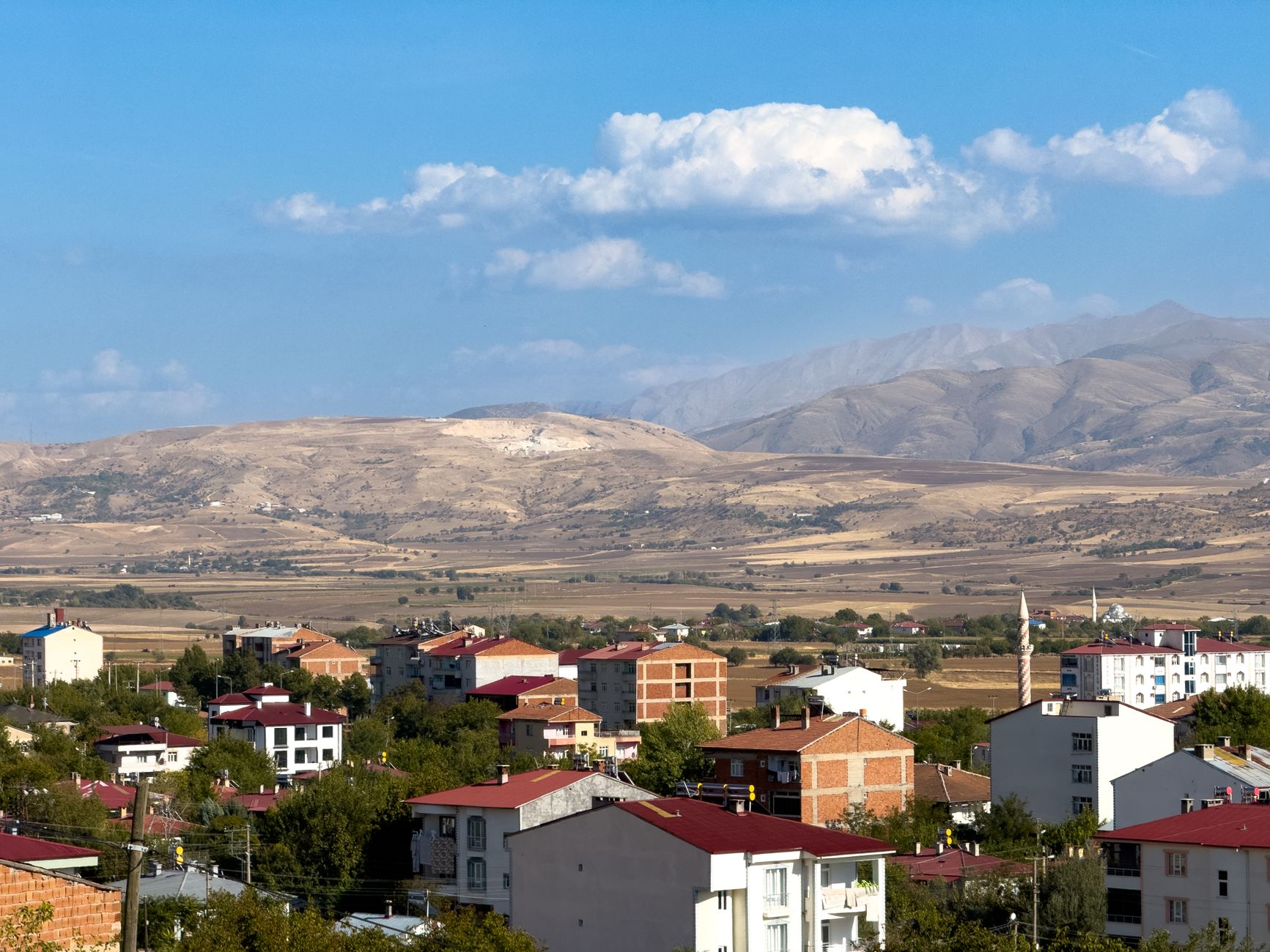 A picturesque view of Kovancılar, Elazığ with red-roofed houses and mountain landscape. — Navigating the Cricket Section on t