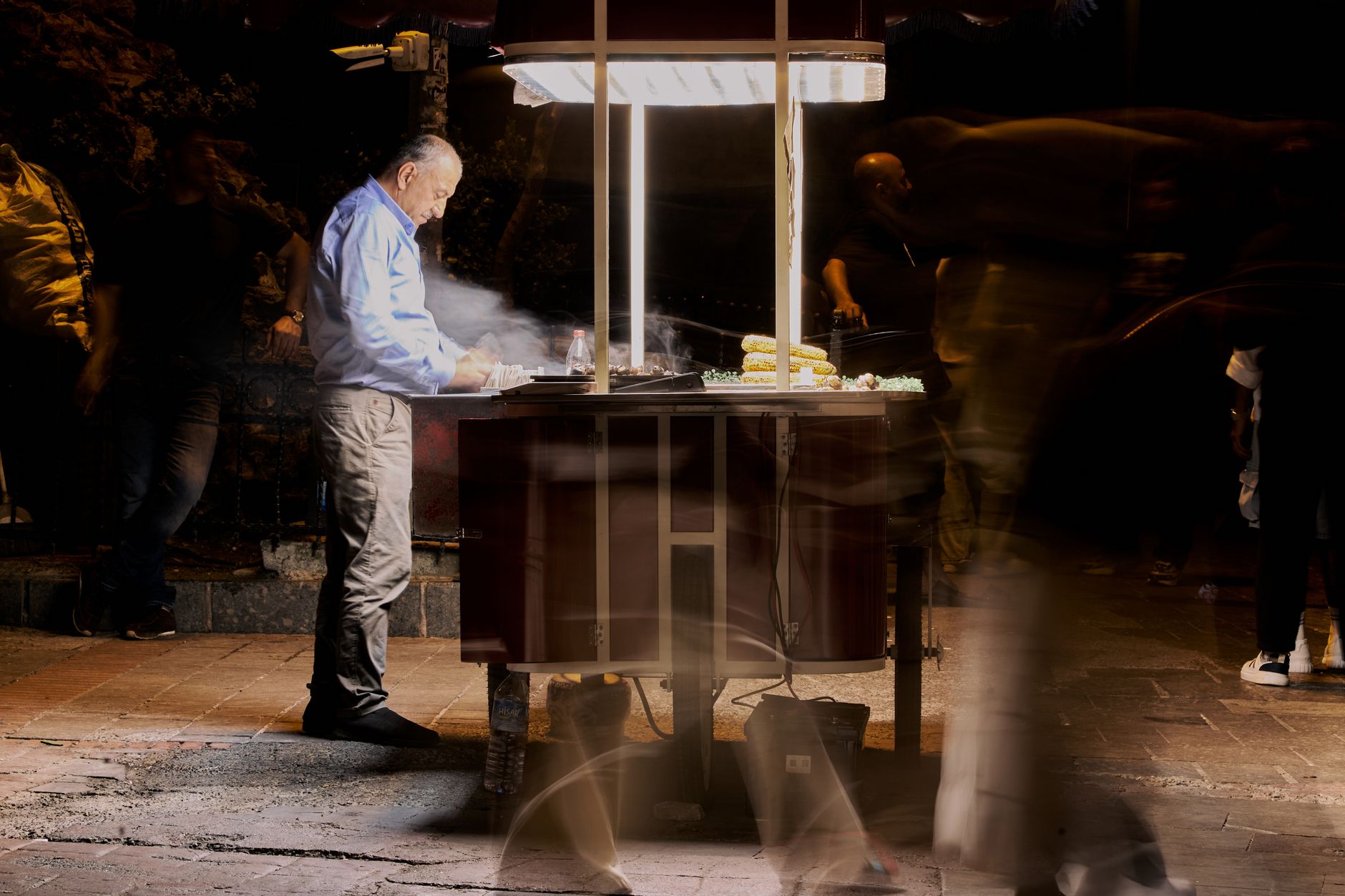 Street vendor cooking food at night with blurred people passing by. — Shaping Tomorrow's Healthcare: MSN in Nursing Practice