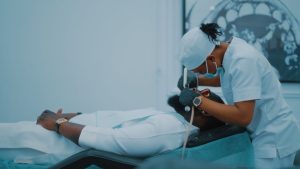 A dental professional performs a procedure on a patient in a Lagos clinic. — Sick Certificate - Quick and Reliable Medical Do