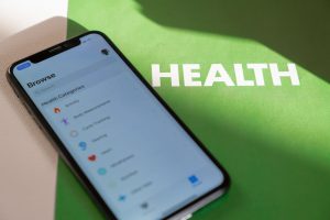 Close-up of a smartphone displaying a health app on a green surface with 'HEALTH' text. — Smoking, Dry Heating, and Vaping Ca