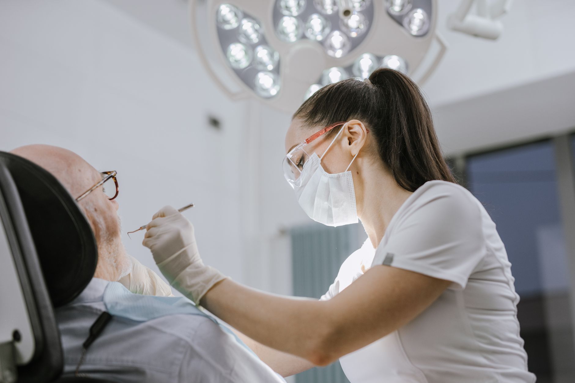 Female dentist working on a patient in a modern dental office with bright lighting. — Some Hidden Traits Of All On 4 Treatmen
