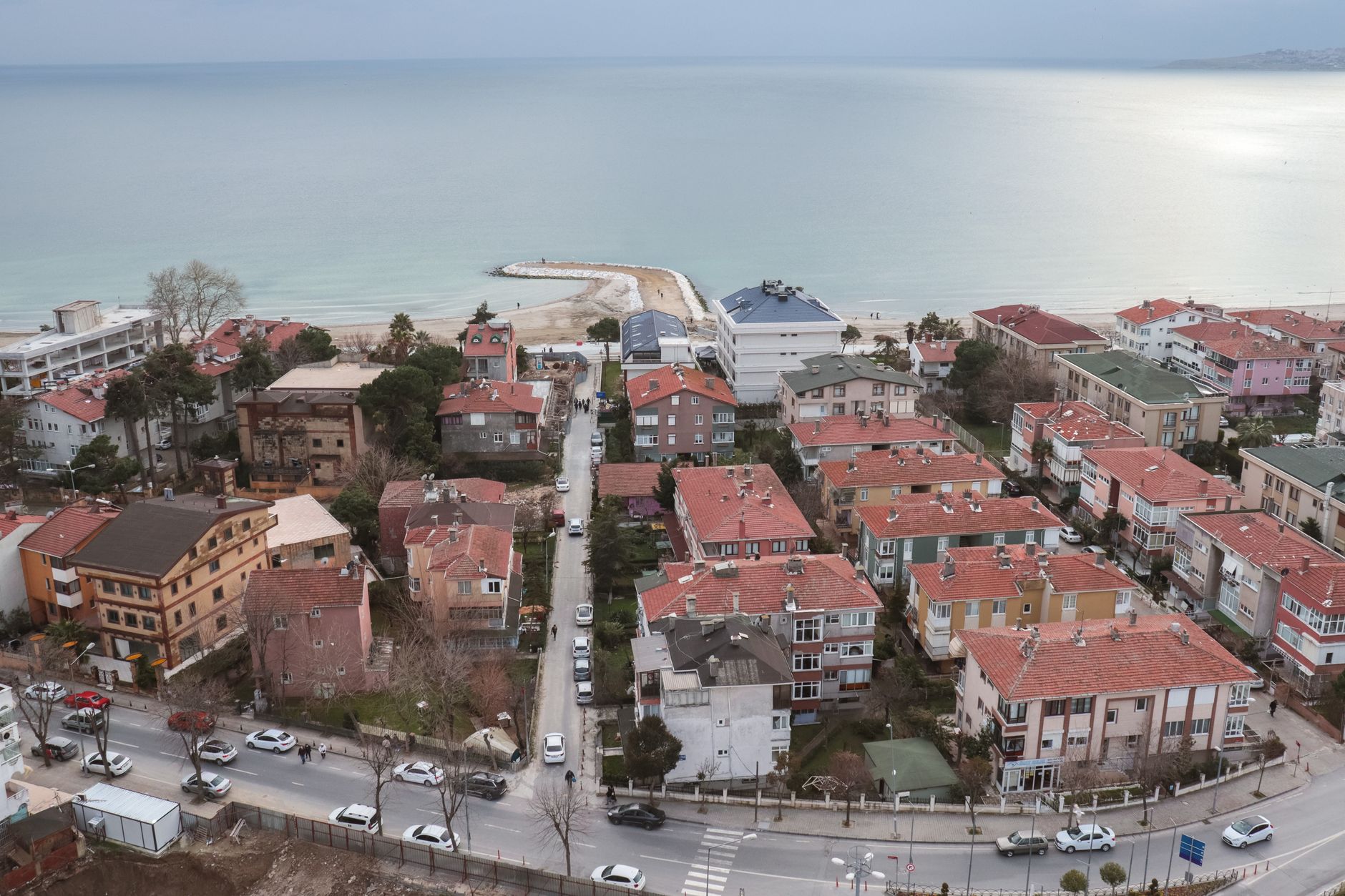 Aerial shot of a picturesque coastal town with red rooftops and a serene ocean view. — Learn More on Whey Isolate and