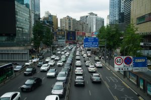 Heavy traffic on a busy Shanghai street lined with skyscrapers and billboards during the day. — Teaching English in P
