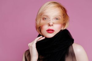 Stylish portrait of a woman wearing a black scarf with pink background, showcasing elegance. — The Beauty of Black Chandelier