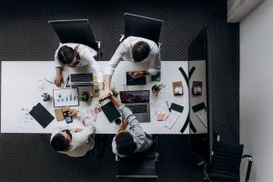 High angle view of colleagues collaborating around a conference table in a modern office setting. — The Efficacy and Uses of