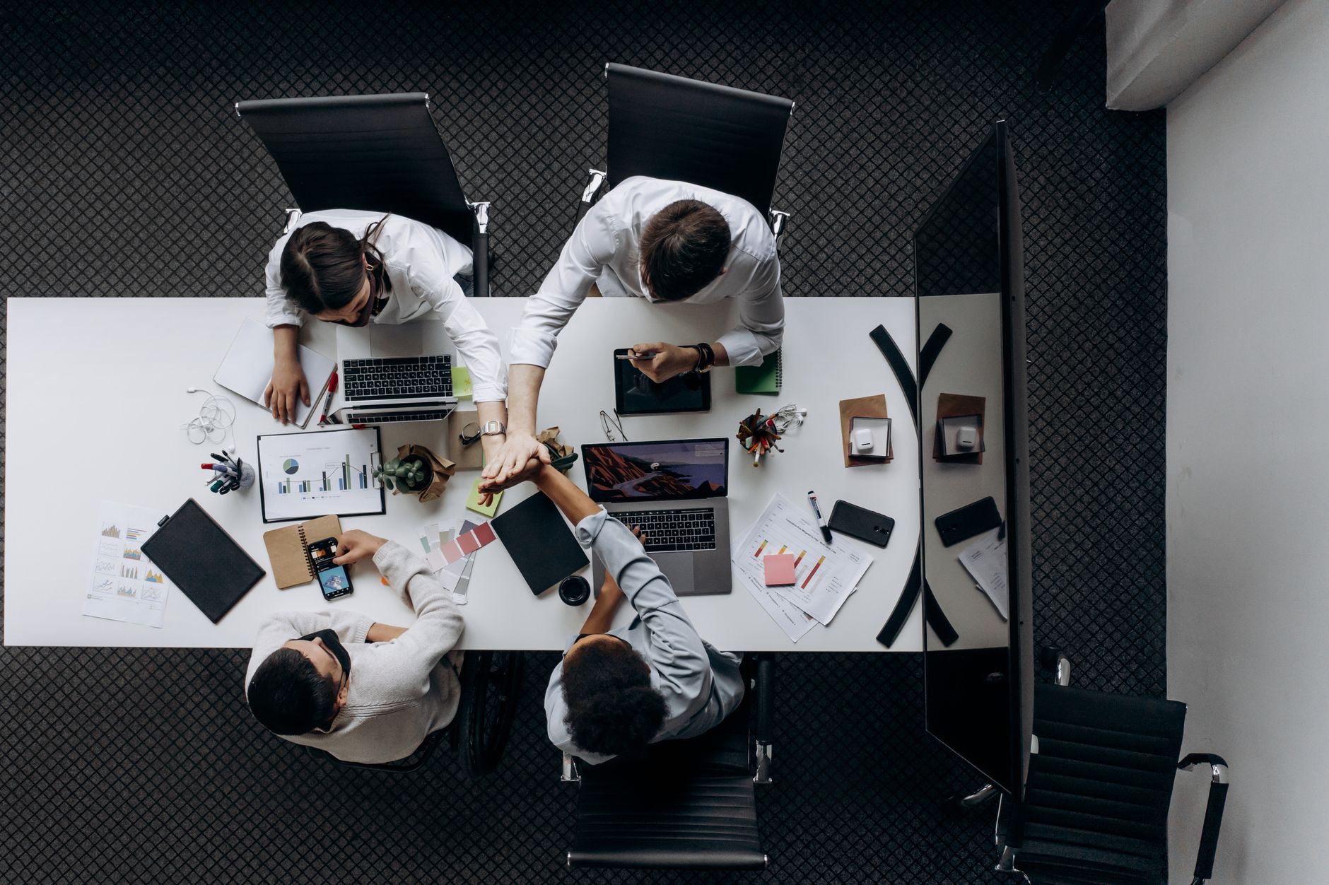 High angle view of colleagues collaborating around a conference table in a modern office setting. — The Efficacy and Uses of