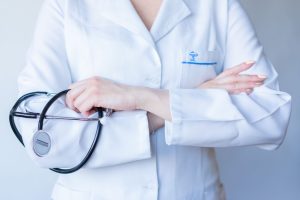 A close-up image of a doctor in a white coat with a stethoscope and arms crossed. — The United Recovery Project provides Diff