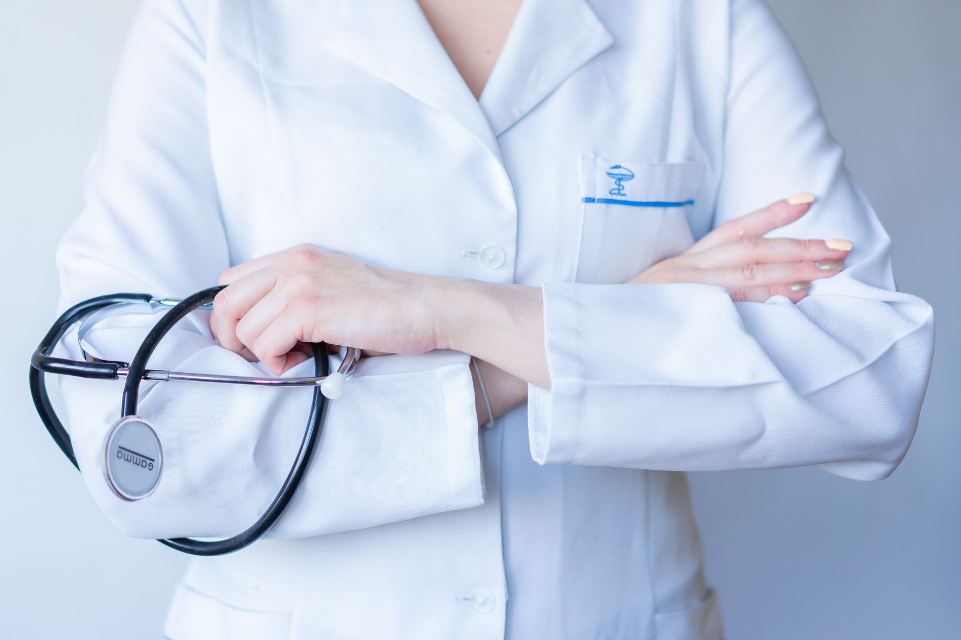 A close-up image of a doctor in a white coat with a stethoscope and arms crossed. — The United Recovery Project provides Diff