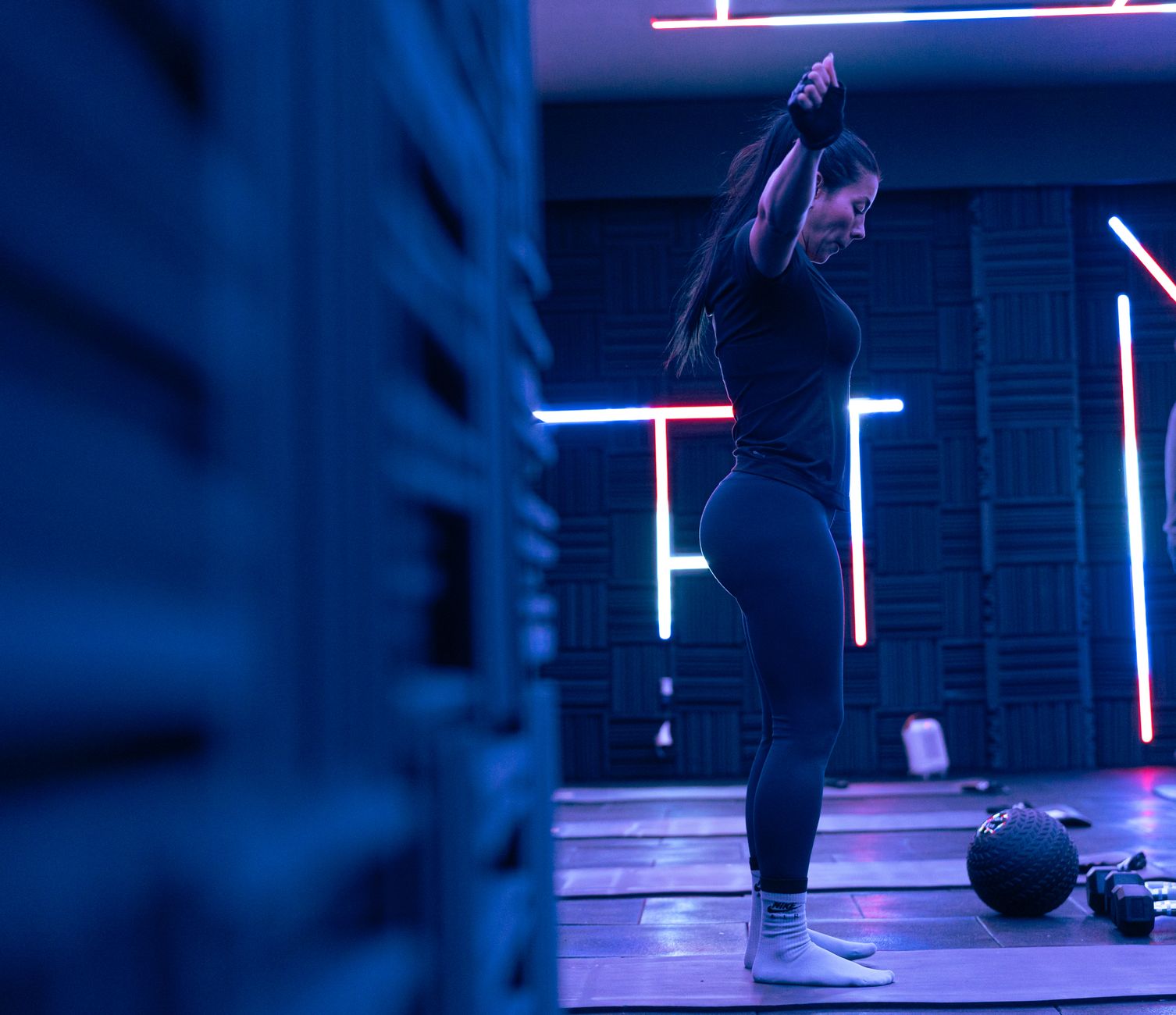 Fitness enthusiast exercising in a stylish neon-lit studio, embodying strength and focus. — Types Of Fitness Exercises