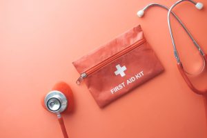 Medical tools including a stethoscope and first aid kit on a pink surface, perfect for healthcare themes. — Understanding Sil