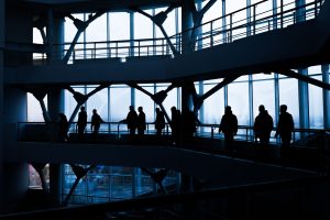 Silhouettes of people walking in a modern architectural building with large windows. — Understanding Tramadol 100MG: Uses, Do