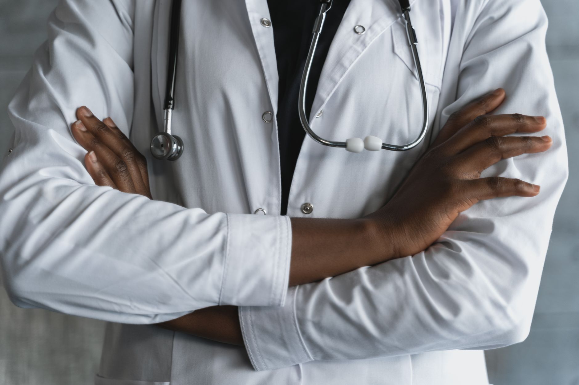 Close-up of a confident doctor in a lab coat standing with crossed arms and stethoscope. — What Products Do You Need for Lash