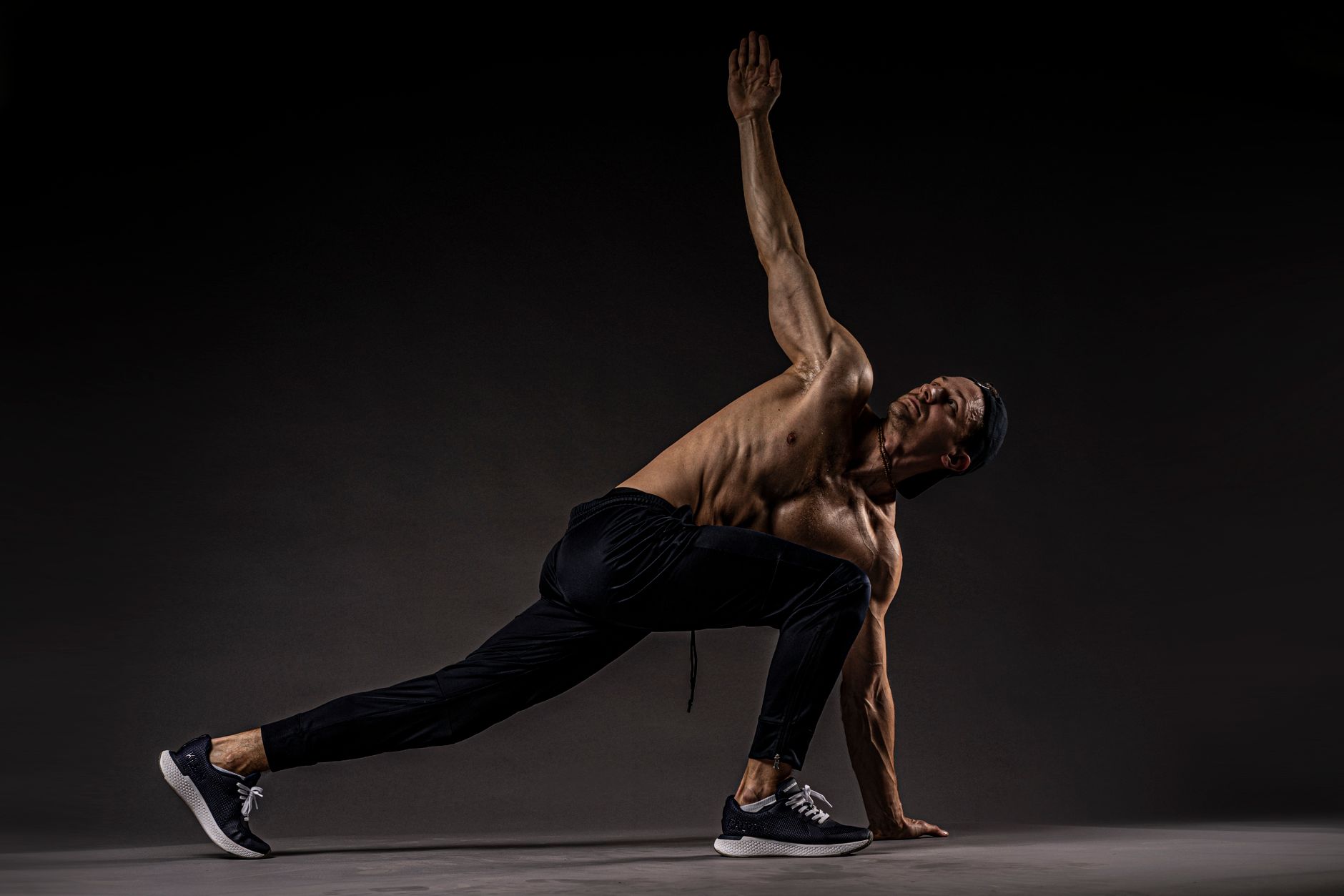 Shirtless man performing fitness stretch highlighting muscles and flexibility. — When should we consider meeting osteopath